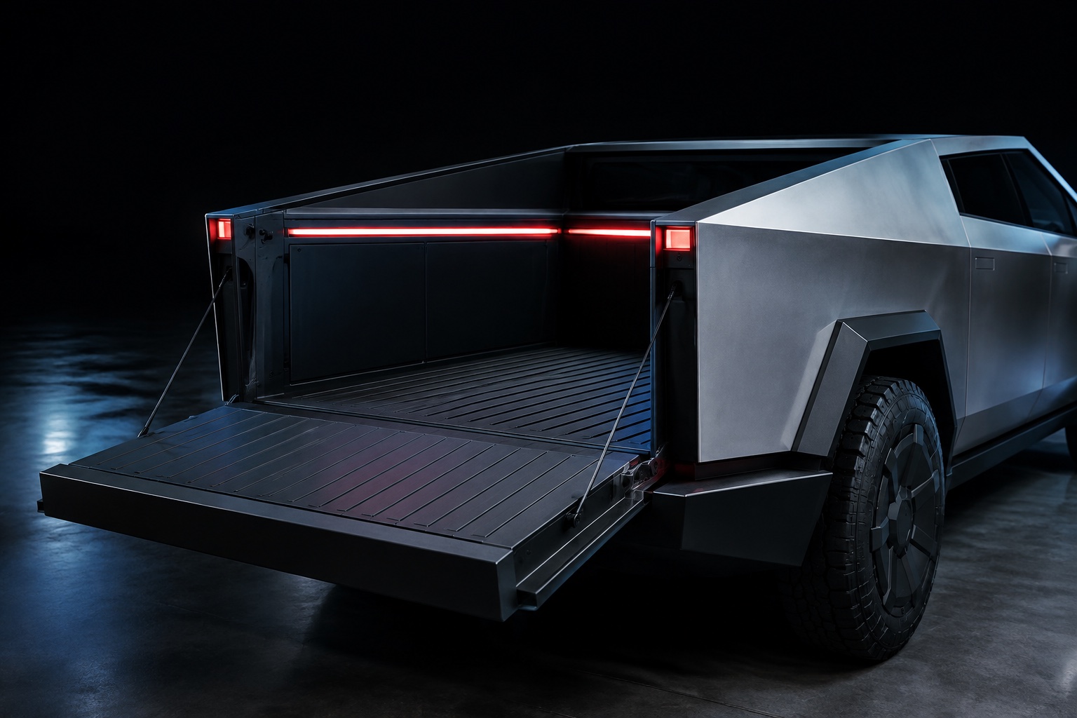 Open Cybertruck cargo bed and lowered tailgate in a dark studio