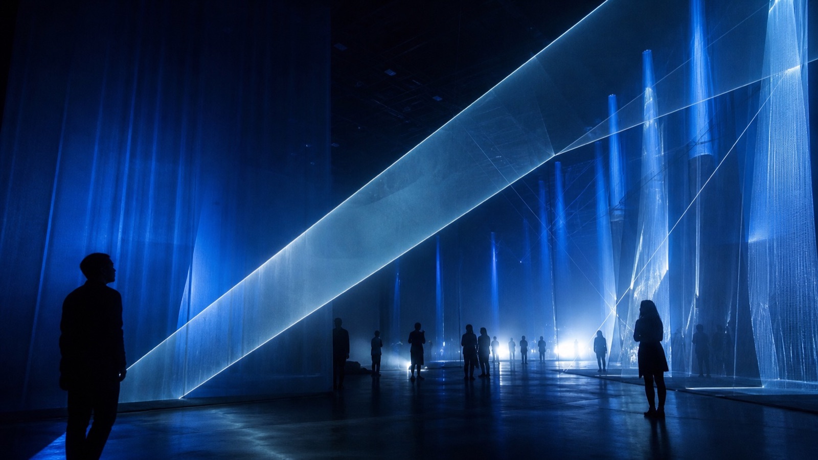 Visitors walking through an immersive blue light installation