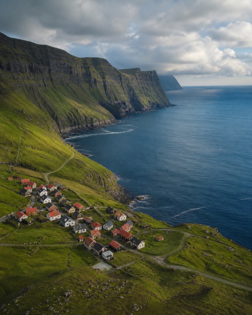 A coastal village beneath green cliffs in the Faroe Islands