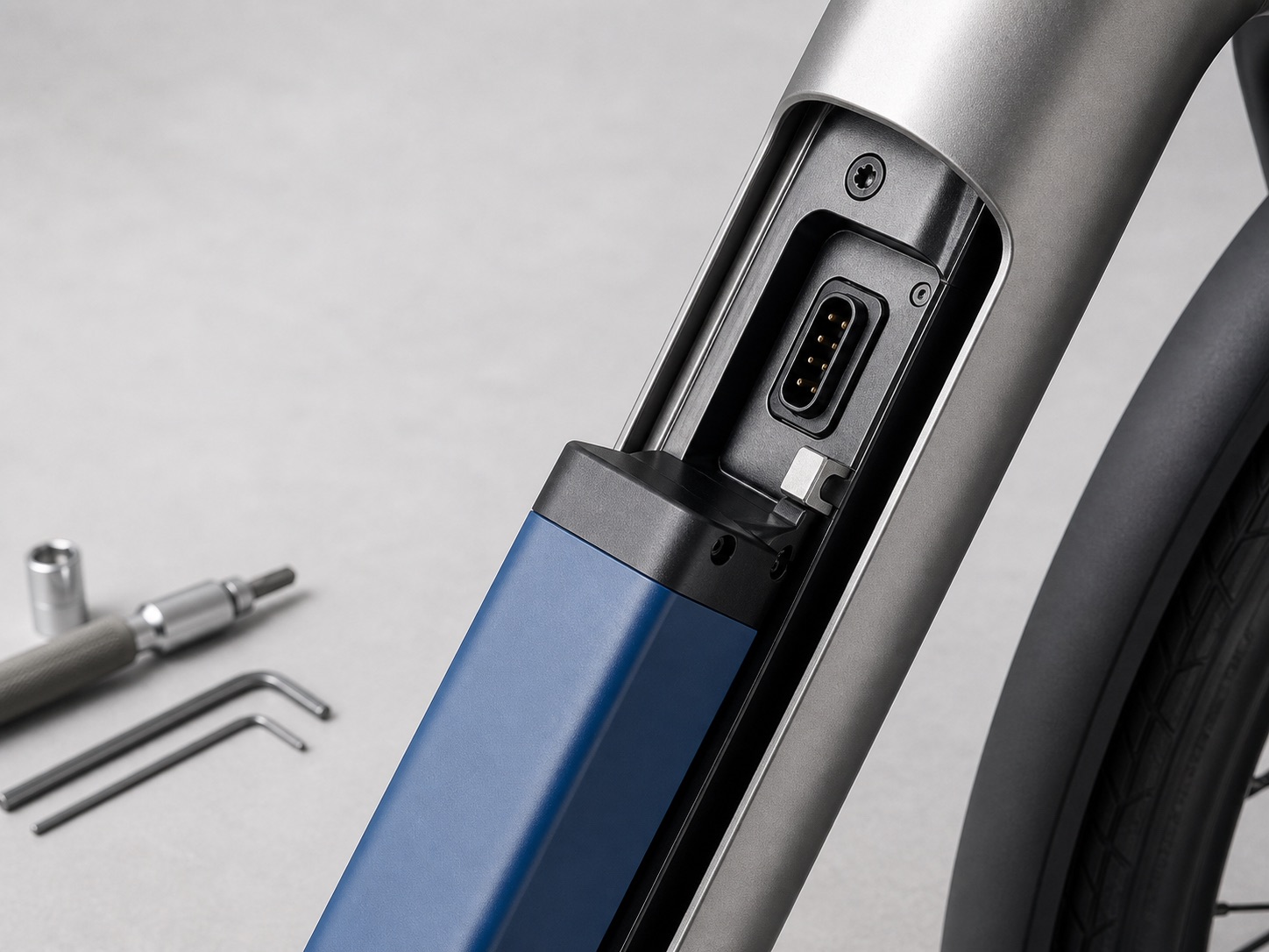 Close view of a cobalt battery cartridge released from the Shift bicycle down tube beside standard workshop tools